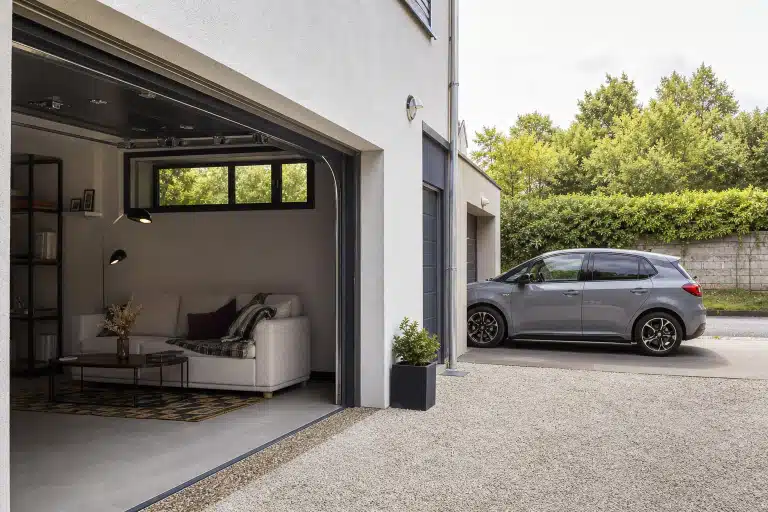 Garage ouvert donnant sur salon et voiture garée